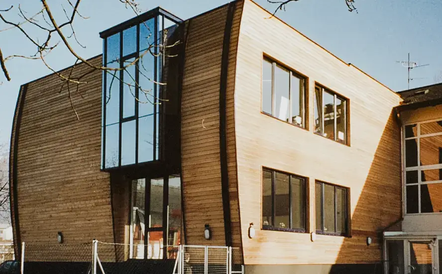 Natürliche Holzfassade an einem Schulgebäude – realisiert von RM Holzbau