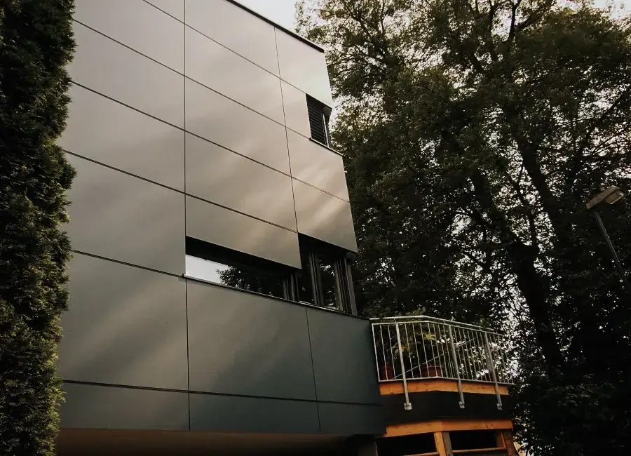 Anthrazitfarbene Metallfassade mit modernem Balkon – umgesetzt von RM Holzbau