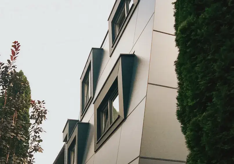 Moderne graue Holzfassade mit zahlreichen Fenstern von RM Holzbau